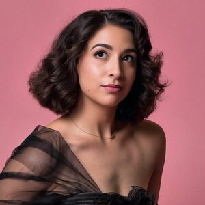 Portrait of soprano Kresley Figueroa against a pink background